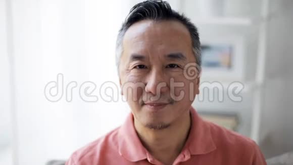 一个微笑的亚洲男人在家的脸视频的预览图