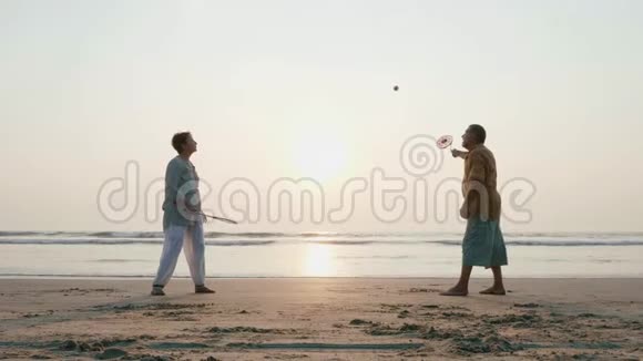 活跃的老夫妇在海滩上缓慢地打太极球视频的预览图