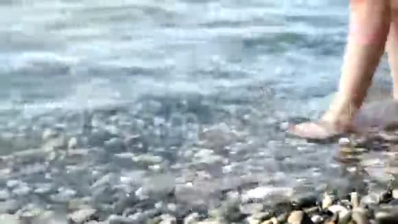 一个美丽的女孩在海水中行走的美腿视频的预览图