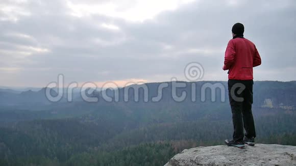 徒步旅行者穿着粉红色运动服在岩石的观点和拍摄薄雾的早晨景观在岩石里远足视频的预览图