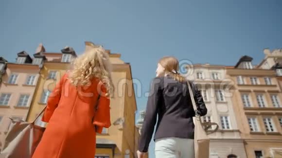 两个年轻的好女人走过城市说话和微笑视频的预览图