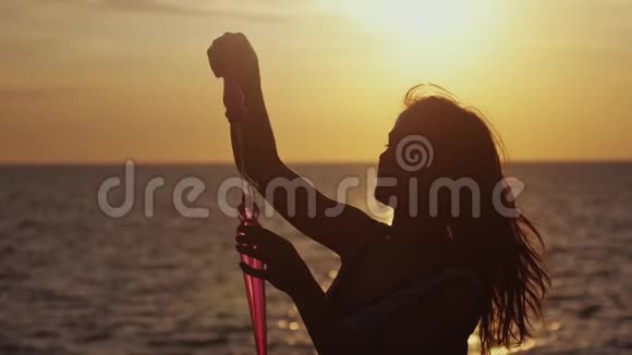 在美丽的日落海边快乐的黑发女人在海滩上吹肥皂泡慢动作1920x1080视频的预览图