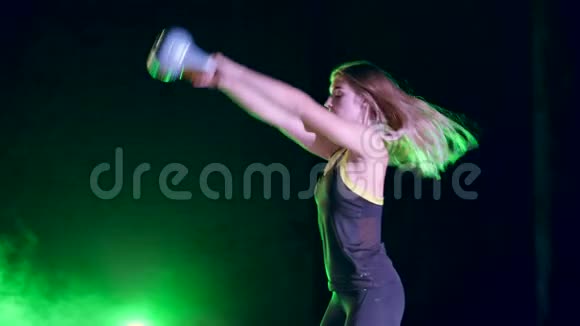 运动美丽年轻的女人做各种力量锻炼与重量夜晚在五彩的灯光下视频的预览图