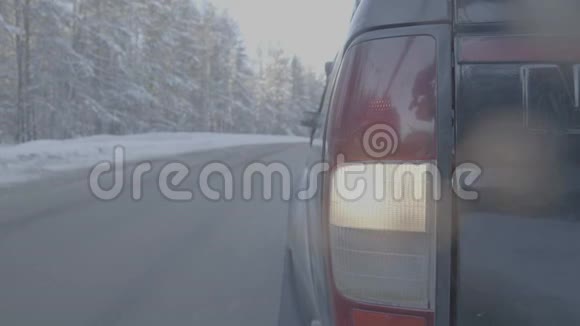 雪道上的大灯特写这辆车骑在一条积雪的道路上视频的预览图