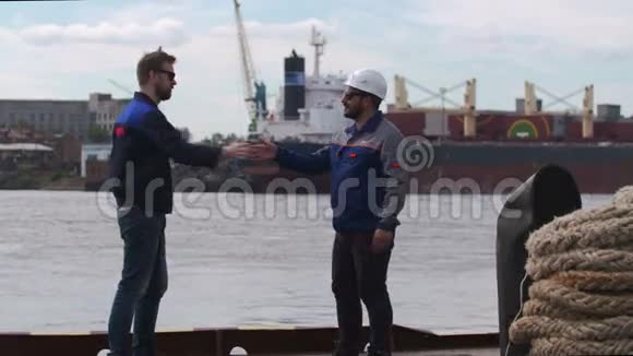 两位好朋友码头工人和同事在海运货物港高举五道别视频的预览图