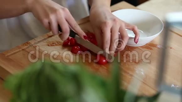 女人亲手切樱桃西红柿放在白碗里视频的预览图