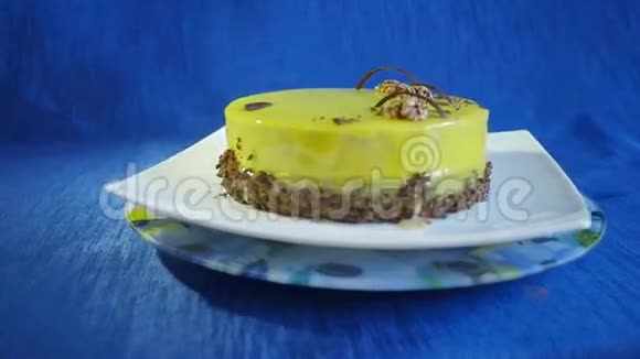 带坚果和巧克力的绿色摩丝蛋糕深蓝色背景上的蛋糕慢动作视频的预览图