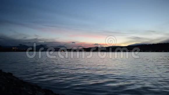 粉红色和五颜六色的黎明天空在特罗姆瑟市的岛屿上蓝色峡湾的倒影视频的预览图
