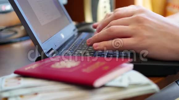 双手在笔记本电脑上输入文字特写金钱和护照视频的预览图
