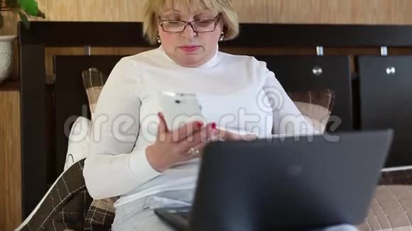 有笔记本电脑和白色手机的女人视频的预览图
