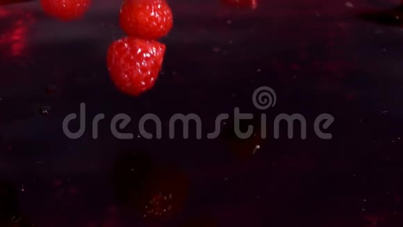 红色多汁的覆盆子掉进果汁里视频的预览图