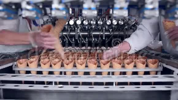 移动皮带与冰淇淋锥和工人的手放他们食品工业视频的预览图