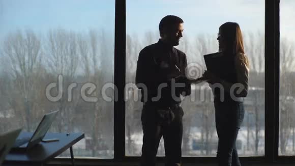 商务人士的身影站在办公室的全景窗口上视频的预览图
