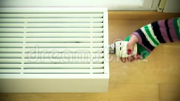 带手套的女性手臂增加散热器温度和温暖的手视频的预览图