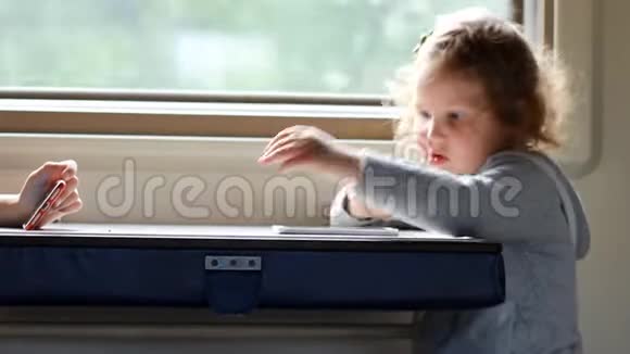 女孩在火车上玩智能手机游戏宝宝在马路上玩手机游戏视频的预览图
