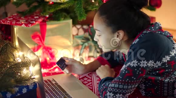 年轻的黑人妇女在圣诞节前夕上网购物视频的预览图
