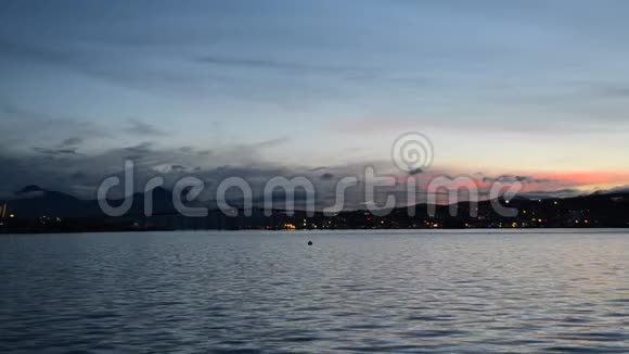 粉红色和五颜六色的黎明天空在特罗姆瑟市的岛屿上蓝色峡湾的倒影视频的预览图