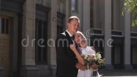 新娘和新郎在城市的柱子中行走亲吻和拥抱相爱的一对视频的预览图