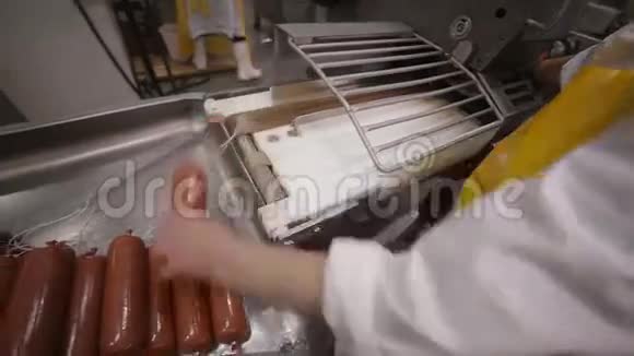 肉类美食制作工人手操作香肠和肉制品的自动化生产线视频的预览图