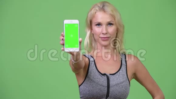 年轻快乐的美女带着手机去健身房视频的预览图