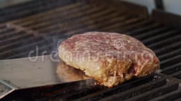 在靠近火焰和烟雾的烤架上缓慢移动牛肉汉堡视频的预览图