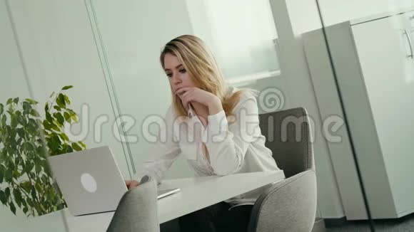 年轻的女商人正在一间明亮的办公室里工作电脑视频的预览图
