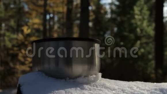站在森林的雪地上蒸杯热茶或咖啡视频的预览图