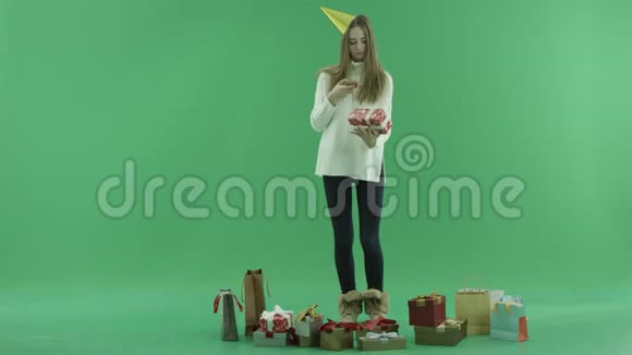 漂亮的年轻女子在背景上为她的圣诞礼物彩色钥匙拍照视频的预览图