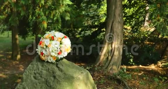 新娘婚礼花束在森林里的石头上视频的预览图