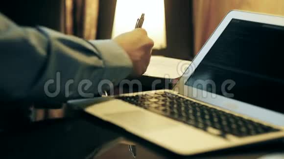 穿衬衫的人在家里的电脑里工作视频的预览图