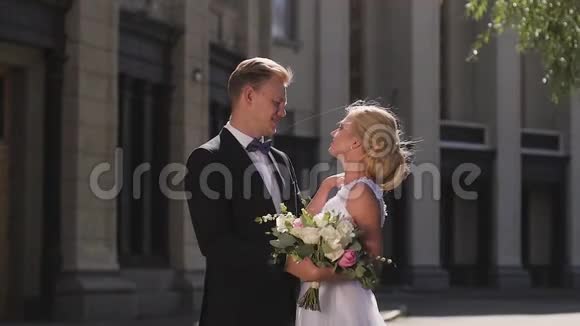 新娘和新郎在城市的柱子中行走亲吻和拥抱相爱的一对视频的预览图