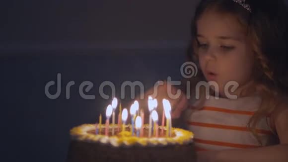 小美丽的女孩正在缓慢地在生日蛋糕上吹九支蜡烛视频的预览图