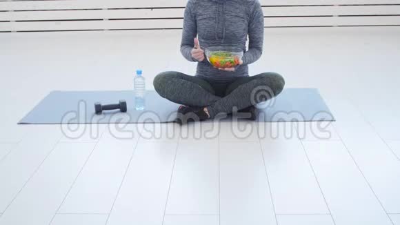 健康的饮食观念年轻的健康女性在锻炼后吃健康沙拉视频的预览图