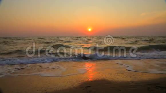 在日落时沿着夏日海滩散步的情侣视频的预览图