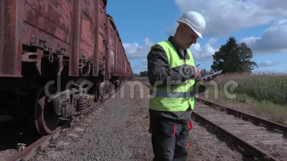 铁路员工在货车旁使用智能手机视频的预览图