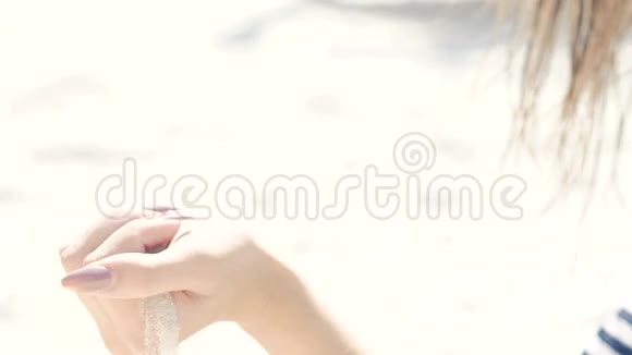 沙子在女人的手里倾泻慢动作视频的预览图