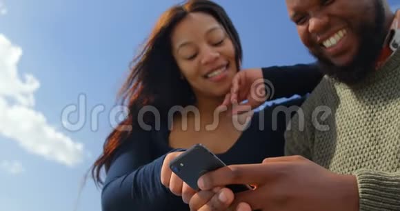 快乐的一对夫妇在阳光明媚的4k使用手机视频的预览图