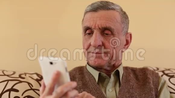 一个年长的男人在她的智能手机里翻来覆去地看照片视频的预览图