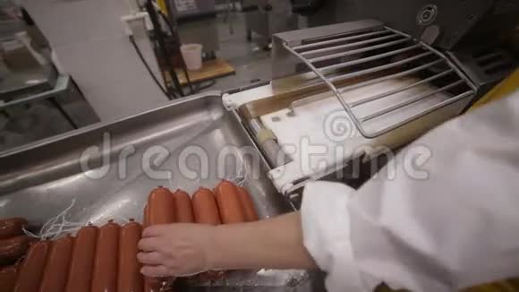 肉类美食制作工人手操作香肠和肉制品的自动化生产线视频的预览图