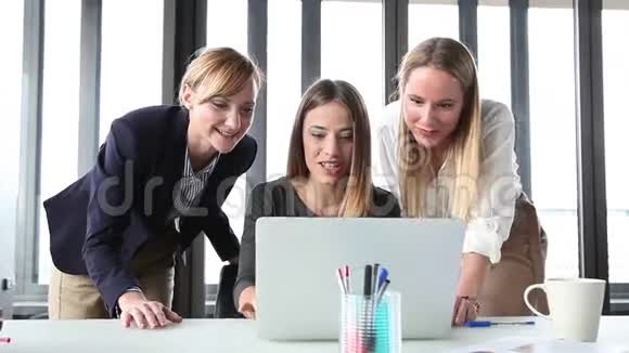 三个快乐的女商人带着笔记本电脑兴高采烈视频的预览图