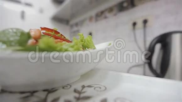 服务员把一道美味的新鲜沙拉菜端到托盘上的桌子上视频的预览图