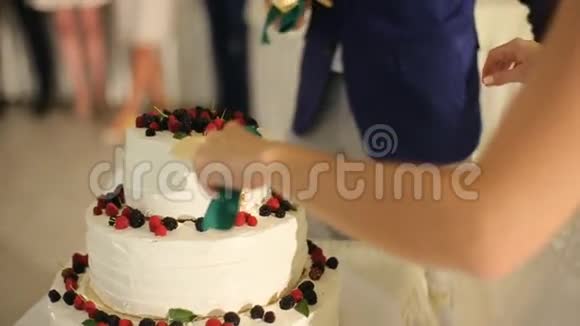 新郎新娘切婚礼饼的刀可以看到新婚夫妇手中的新娘切蛋糕新郎帮忙视频的预览图