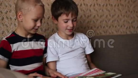 两个男孩坐在沙发上看书视频的预览图
