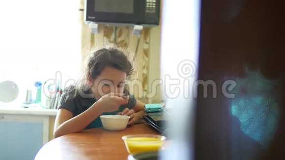在厨房里吃麦片的女孩带着盘子的早餐视频的预览图