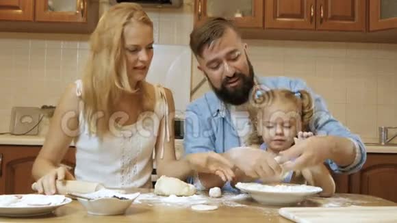 幸福的家庭母亲父亲和小女儿在厨房准备馅饼从测试视频的预览图