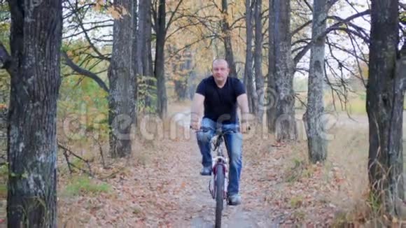 在秋天的森林里骑自行车的人视频的预览图