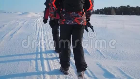 团队合作男游客摄影师冬天乘三脚架爬山顶山顶山顶群去下雪视频的预览图