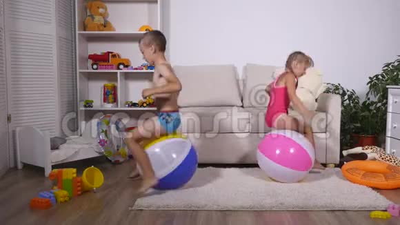 孩子们玩得很开心坐在游戏室里的大橡胶充气球上视频的预览图
