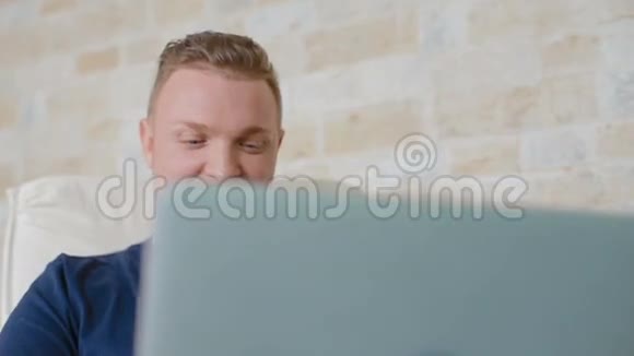 这个人很容易微笑在笔记本电脑后面工作视频的预览图