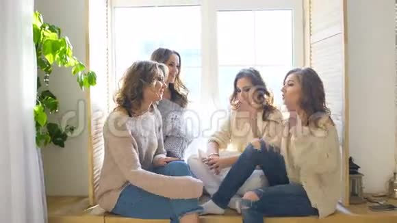 四个漂亮的女孩坐在窗户上讨论微笑女朋友在卧室里玩得开心视频的预览图